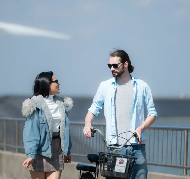 Young couple relaxing by a wind turbine in the Netherlands during a film production shoot